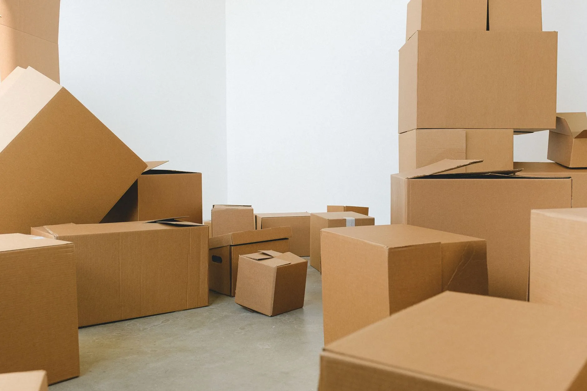 Cartons de déménagement empilés dans une pièce vide avant le tri des affaires